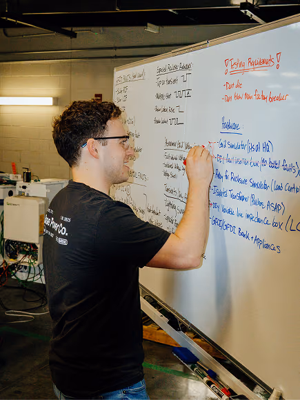 A Base engineer working through a problem at a whiteboard